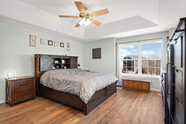 1810 Cherry Cir, Carver, MN 55315 - bedroom featuring a raised ceiling, light wood-style flooring, and a ceiling fan