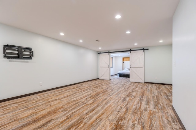 1810 Cherry Cir, Carver, MN 55315 - empty room with a barn door, recessed lighting, and wood finished floors