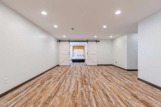 1810 Cherry Cir, Carver, MN 55315 - spare room featuring a barn door, recessed lighting, and wood finished floors