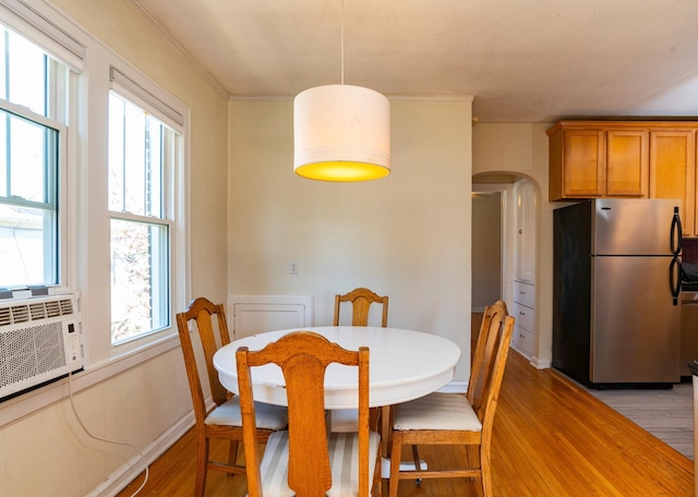 4415 Chowen Ave S Unit 201, Minneapolis, MN 55410 - dining room with light wood-style floors, arched walkways, baseboards, and cooling unit