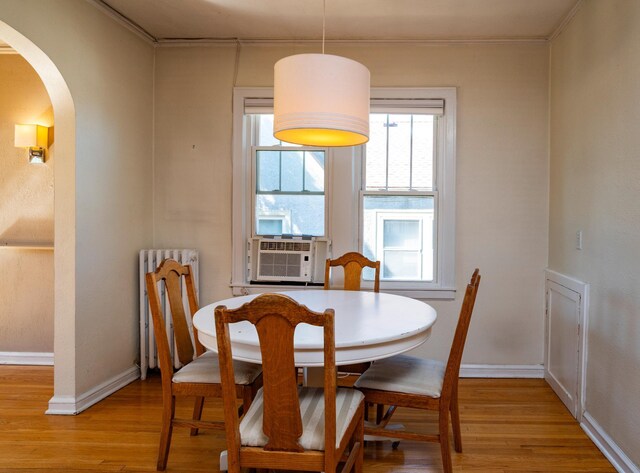 4415 Chowen Ave S Unit 201, Minneapolis, MN 55410 - dining room with arched walkways, light wood-style floors, ornamental molding, radiator heating unit, and cooling unit