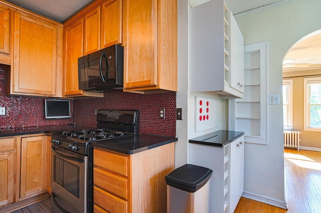 4415 Chowen Ave S Unit 201, Minneapolis, MN 55410 - kitchen with stainless steel range with gas stovetop, black microwave, radiator, open shelves, and arched walkways