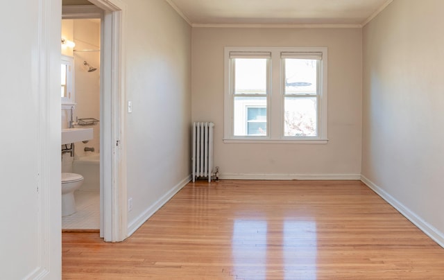4415 Chowen Ave S Unit 201, Minneapolis, MN 55410 - empty room with radiator heating unit, light wood-style flooring, plenty of natural light, ornamental molding, and baseboards