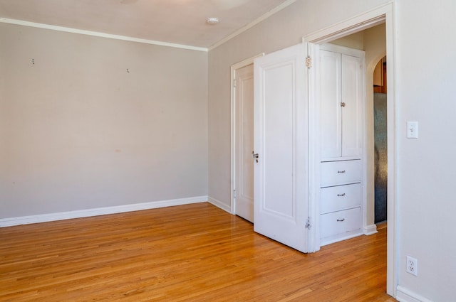4415 Chowen Ave S Unit 201, Minneapolis, MN 55410 - unfurnished bedroom featuring arched walkways, light wood-style floors, baseboards, and crown molding