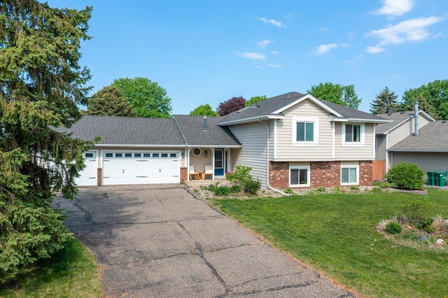 14445 Europa Ave, Apple Valley, MN 55124 - tri-level home with brick siding, an attached garage, asphalt driveway, and a front lawn