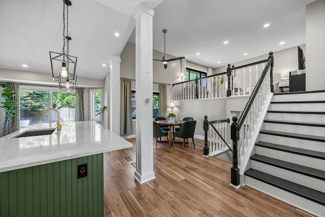 14445 Europa Ave, Apple Valley, MN 55124 - kitchen featuring a sink, light stone countertops, dark wood-type flooring, decorative columns, and recessed lighting