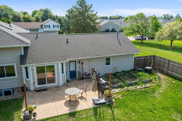 14445 Europa Ave, Apple Valley, MN 55124 - rear view of house with a vegetable garden, a shingled roof, a patio area, and a residential view