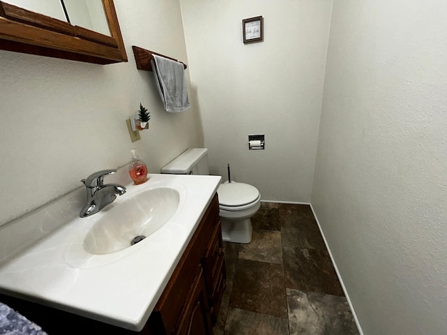 302 Church St, Saint Leo, MN 56264 - bathroom with stone finish floor, vanity, toilet, and baseboards