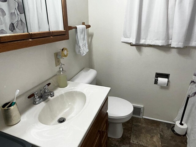 302 Church St, Saint Leo, MN 56264 - bathroom with toilet, baseboards, visible vents, stone finish floor, and vanity