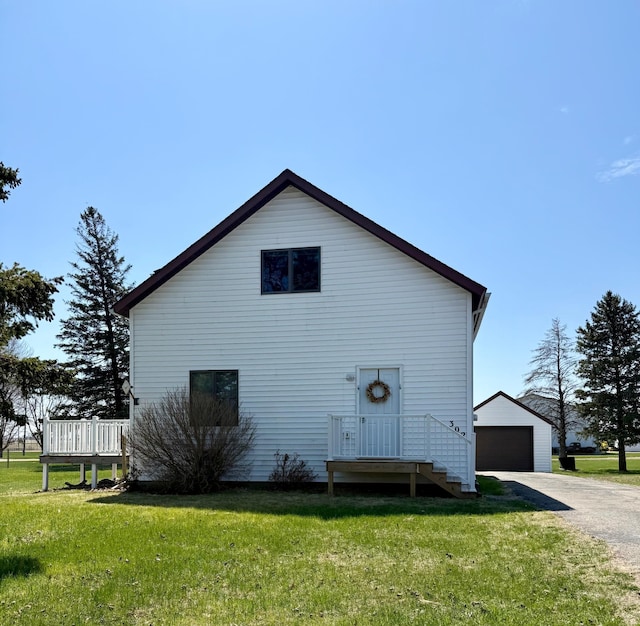 302 Church St, Saint Leo, MN 56264 - rear view of property with an outdoor structure, a yard, and a detached garage