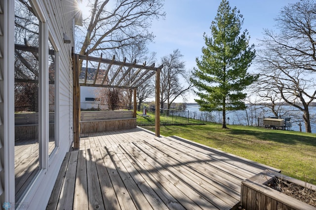 wooden deck with a yard, a water view, and fence