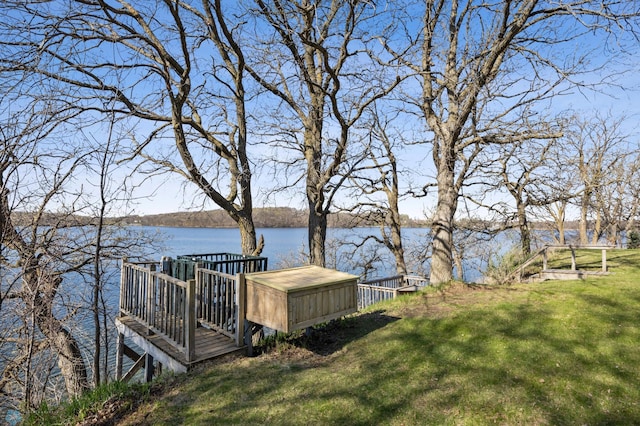 view of home's community with a water view and a lawn