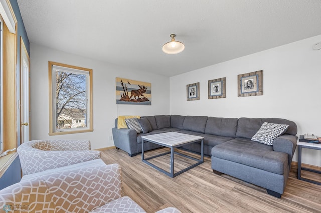 living area featuring light wood finished floors and baseboards