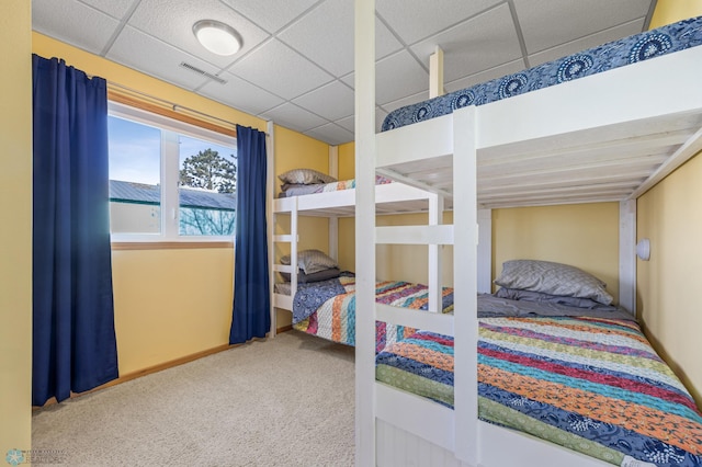 bedroom featuring a drop ceiling, baseboards, visible vents, and carpet floors