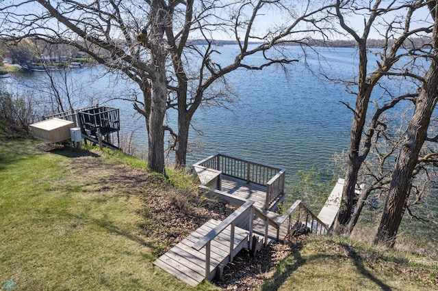 view of dock with a water view and a yard