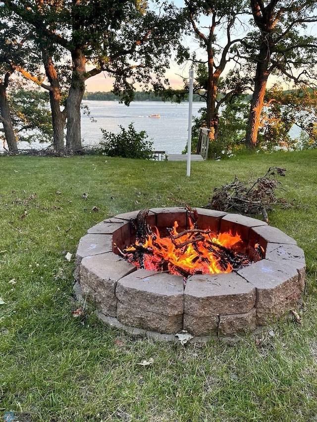 view of yard with an outdoor fire pit and a water view