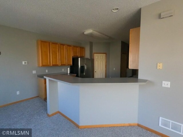 18061 96th Ave N, Maple Grove, MN 55311 - kitchen with stainless steel fridge with ice dispenser, light colored carpet, a textured ceiling, baseboards, and a peninsula