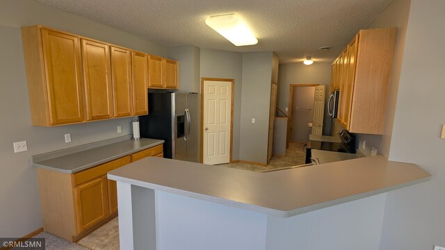 18061 96th Ave N, Maple Grove, MN 55311 - kitchen with stainless steel fridge with ice dispenser, a peninsula, a textured ceiling, washer / clothes dryer, and light countertops