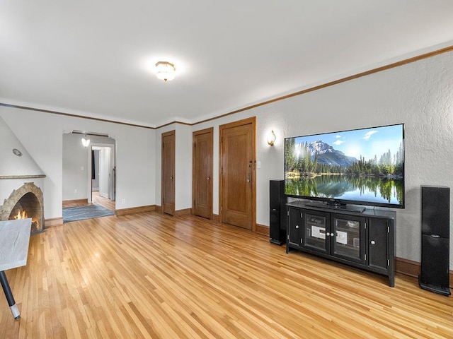 580 Snelling Ave S Unit 4, Saint Paul, MN 55116 - unfurnished living room with baseboards, ornamental molding, a lit fireplace, light wood-type flooring, and a textured wall
