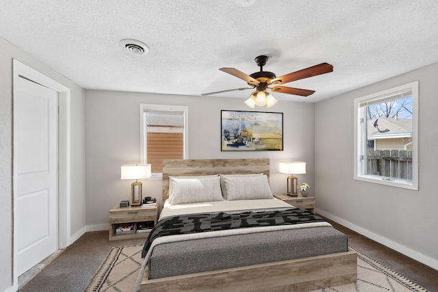 carpeted bedroom with baseboards, a textured ceiling, and visible vents