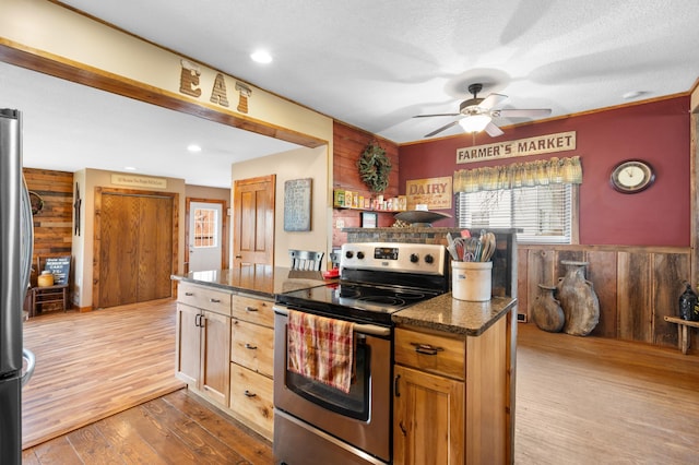12 Oak Ave SE, Racine, MN 55967 - kitchen featuring appliances with stainless steel finishes, wood walls, ceiling fan, wood finished floors, and a wainscoted wall