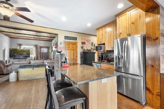 12 Oak Ave SE, Racine, MN 55967 - kitchen featuring appliances with stainless steel finishes, ceiling fan, wood finished floors, a kitchen bar, and tasteful backsplash