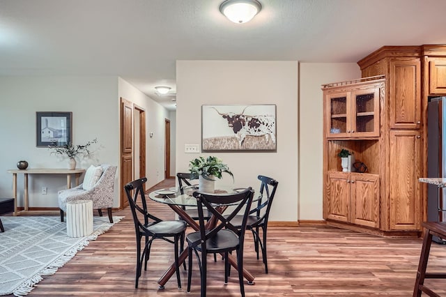 dining space with light wood-style floors and baseboards