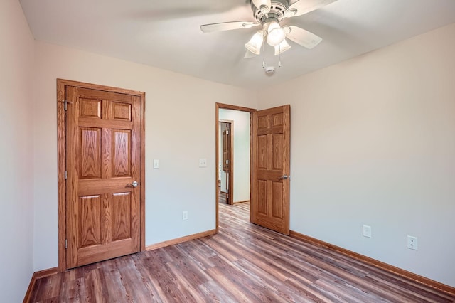 unfurnished bedroom featuring a ceiling fan, baseboards, and wood finished floors