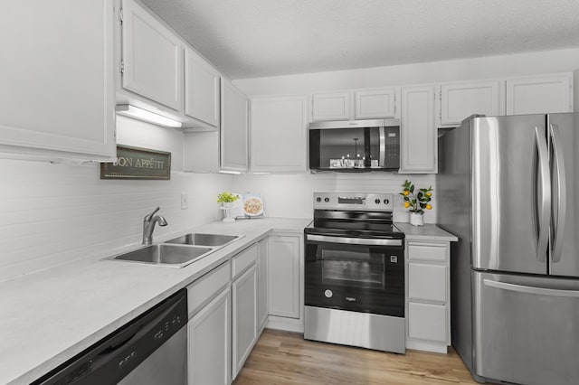 6970 Langford Ct, Edina, MN 55436 - kitchen with stainless steel appliances, a sink, light countertops, light wood-type flooring, and tasteful backsplash