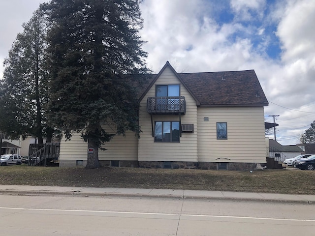 view of home's exterior with roof with shingles and a wall mounted air conditioner