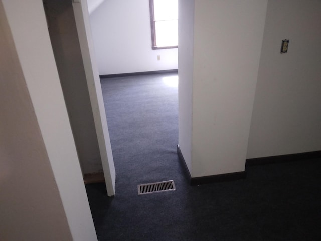 hall with baseboards, carpet, and visible vents