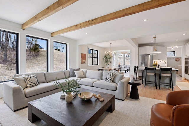 living area with recessed lighting, light wood-style floors, and an inviting chandelier
