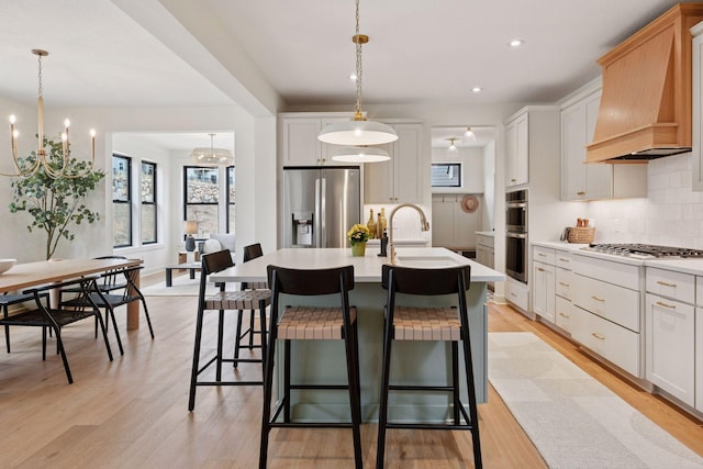kitchen featuring stainless steel appliances, a sink, custom exhaust hood, decorative backsplash, and light countertops
