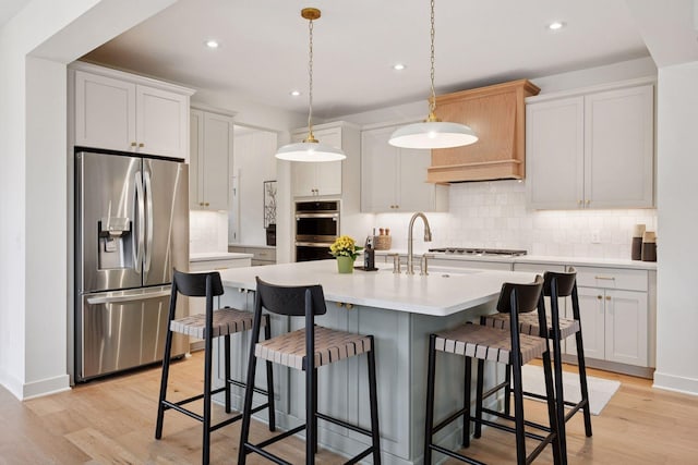 kitchen with backsplash, recessed lighting, appliances with stainless steel finishes, and light countertops