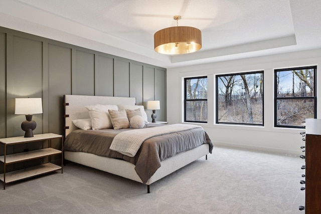 carpeted bedroom with a tray ceiling