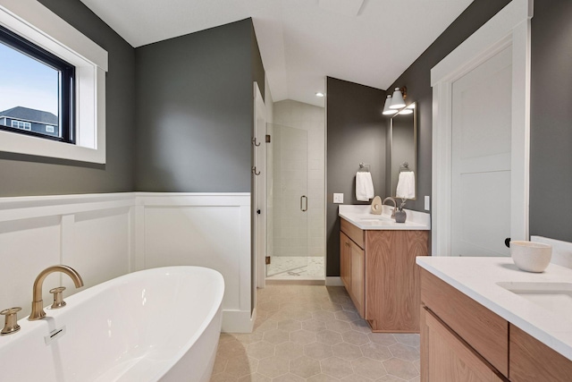 bathroom with tile patterned floors, a sink, two vanities, a freestanding bath, and a shower stall