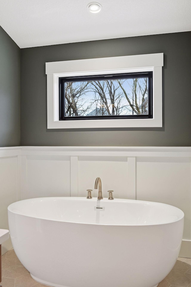 full bath featuring a soaking tub, tile patterned floors, and a healthy amount of sunlight