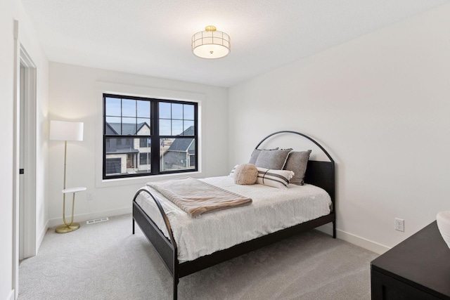 bedroom featuring visible vents, baseboards, and light colored carpet