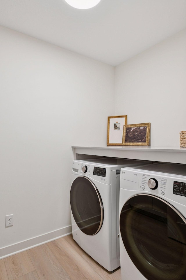 washroom with independent washer and dryer, light wood-style floors, baseboards, and laundry area