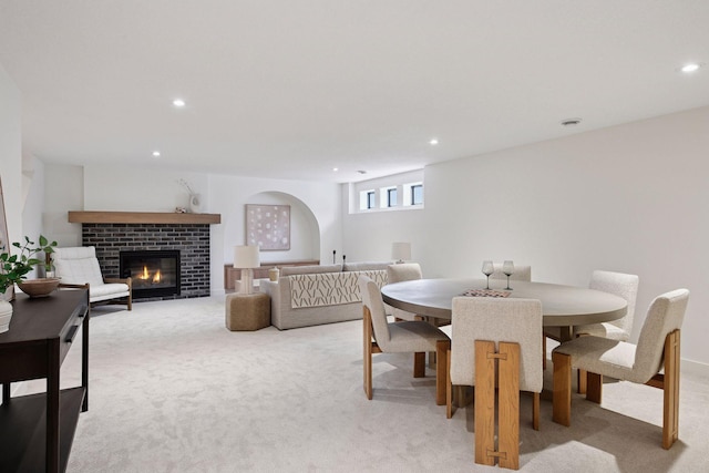 dining room featuring light carpet, a brick fireplace, and recessed lighting