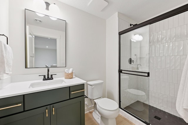 bathroom with a shower stall, wood finished floors, toilet, vanity, and baseboards