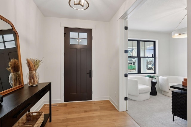 entryway with light wood-type flooring, visible vents, and baseboards