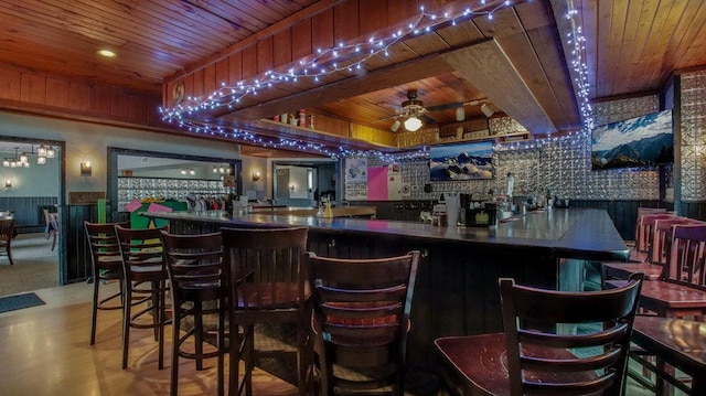 bar featuring wooden ceiling, ceiling fan, and a community bar