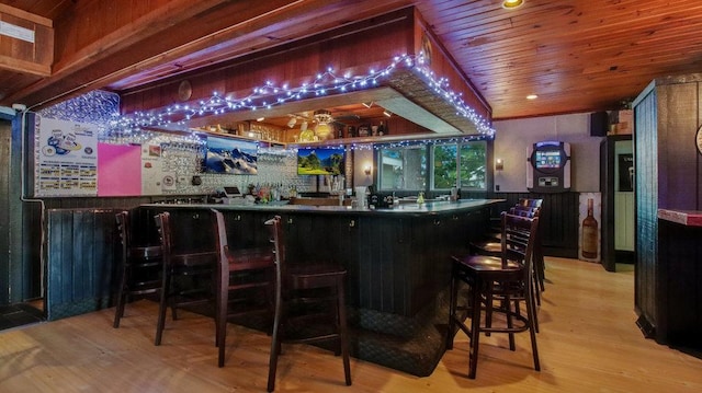 bar with wood finished floors, wooden ceiling, and a community bar