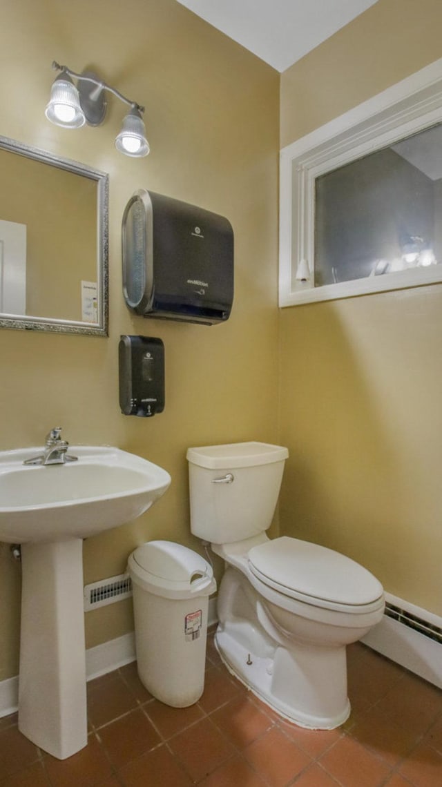 bathroom featuring baseboards, toilet, baseboard heating, and tile patterned floors