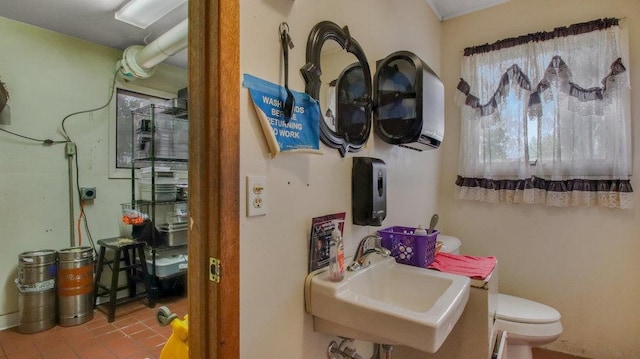 half bathroom featuring toilet, tile patterned flooring, and a sink