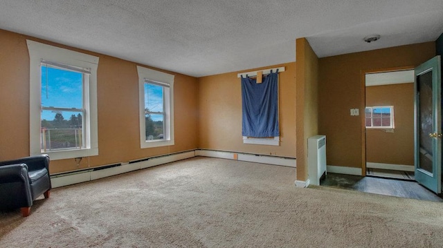 unfurnished living room featuring radiator heating unit, carpet, a textured ceiling, and a baseboard radiator