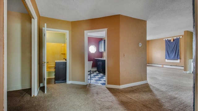 hall featuring a baseboard radiator, baseboards, carpet flooring, and a textured ceiling