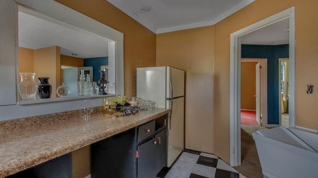 kitchen featuring light countertops, freestanding refrigerator, and light floors