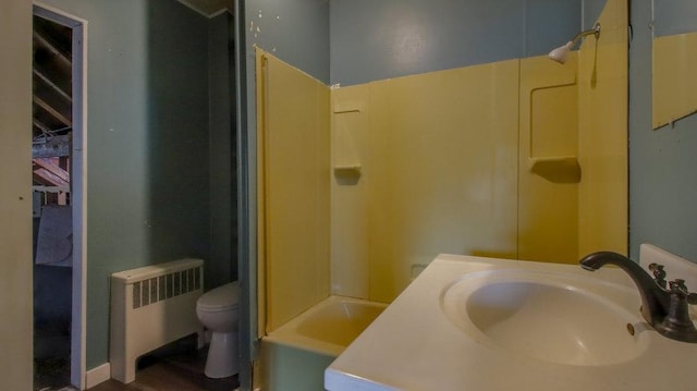 full bathroom with radiator heating unit, vanity, and toilet